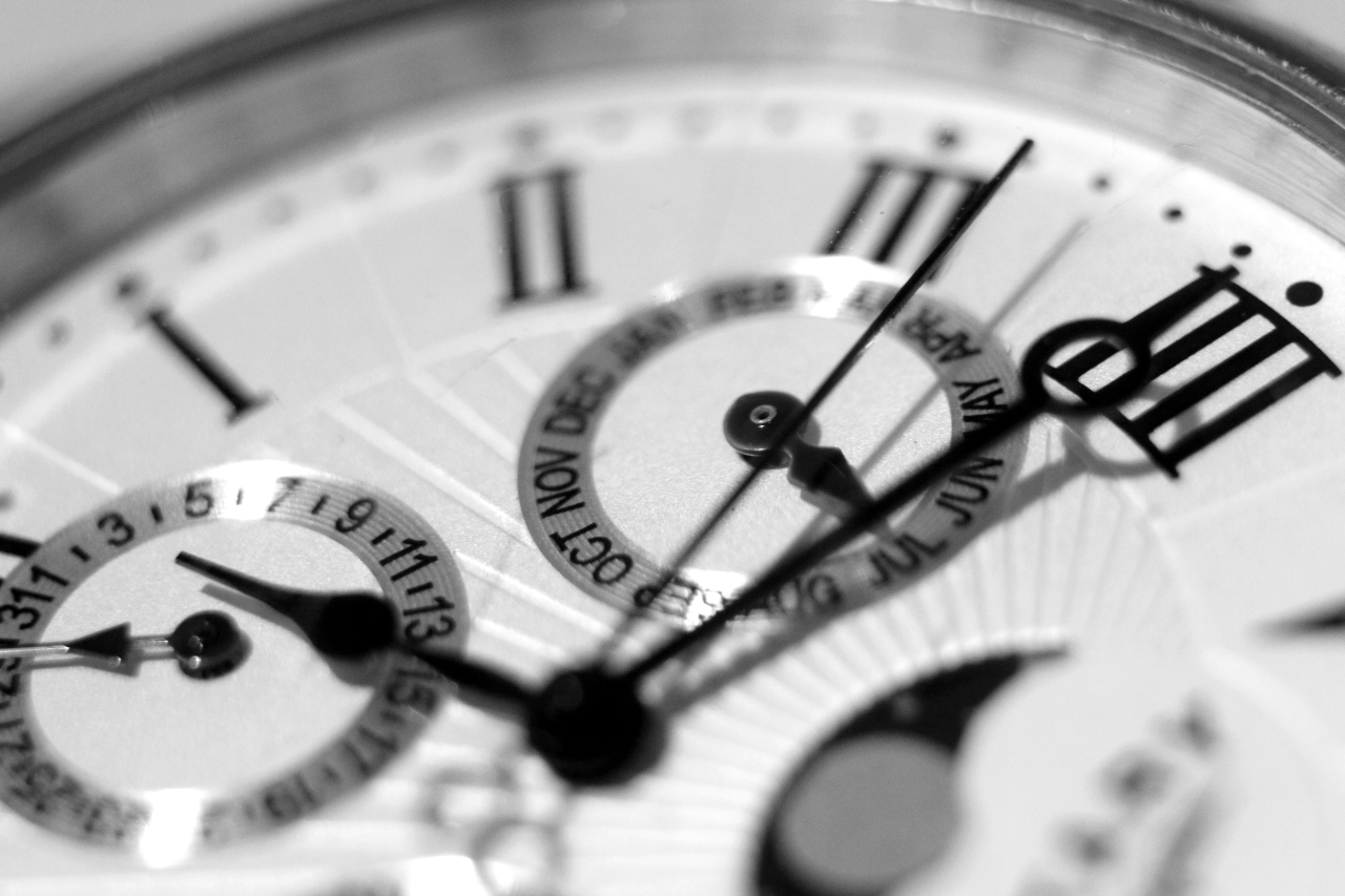 A black and white picture of a watch face featuring Roman numerals and multiple complications.