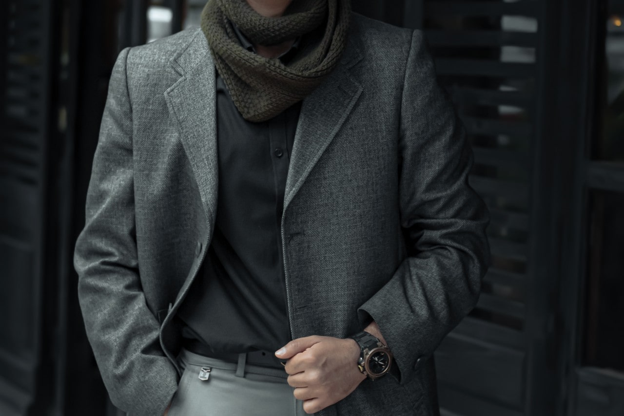 a man in stylish clothes wearing a round case watch