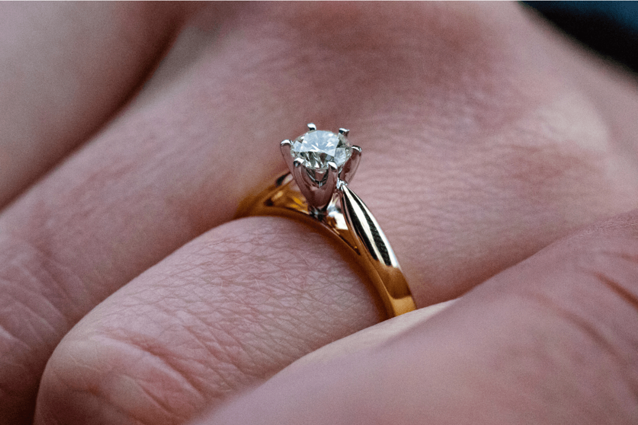 solitaire engagement ring on a finger