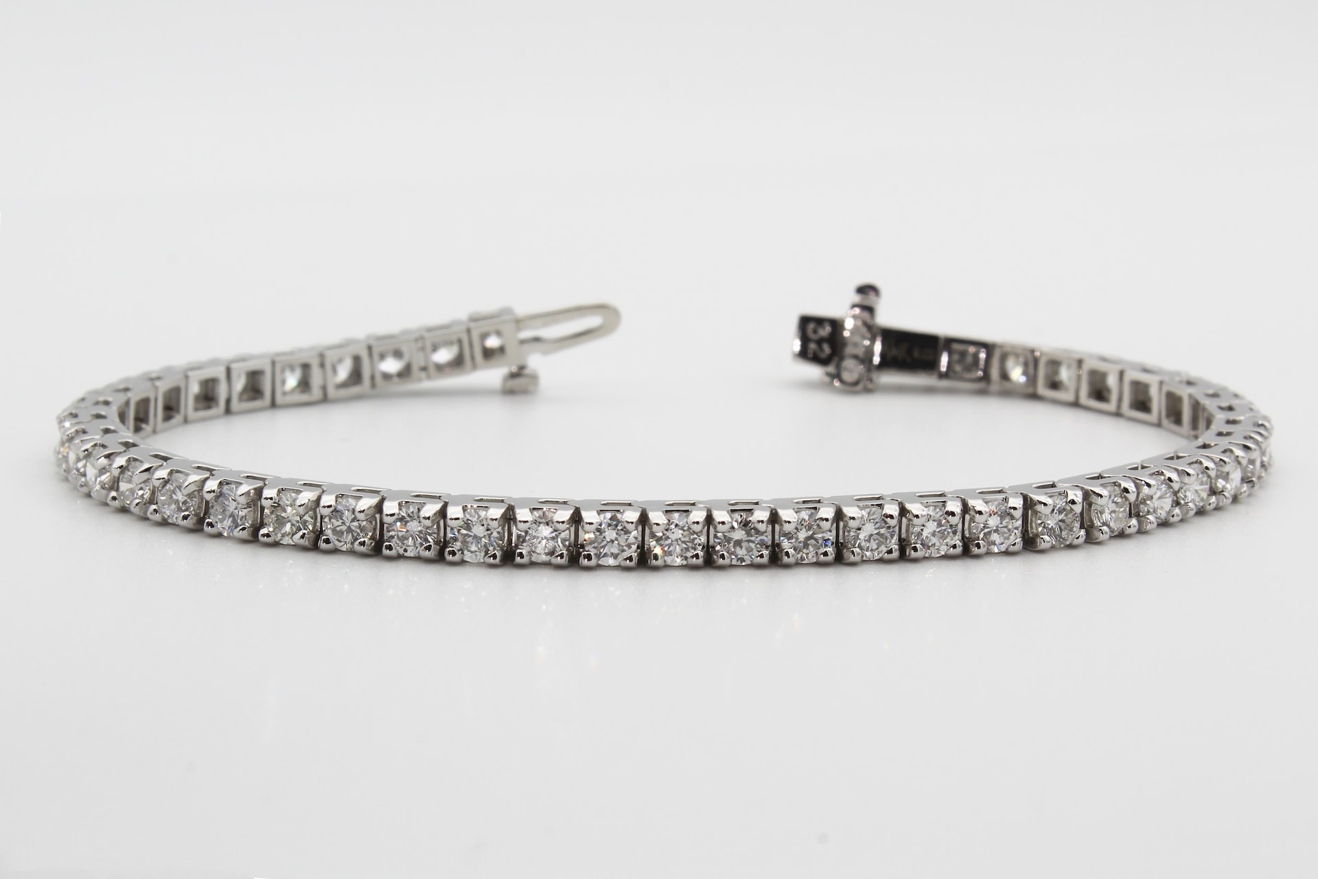 Elegant white gold tennis bracelet with a line of sparkling diamonds set in square links.